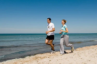 Spazierengehen und Joggen am Strand Jogger am Strand