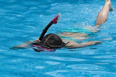 Baden und Schwimmen im Schwimmbad Tauchendes Kind im Schwimmbecken
